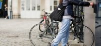 Photo pour illustrer un article avec les conseils vélo pour l'été 2024 : une cycliste accède à un parking vélo Île-de-France Mobilités.