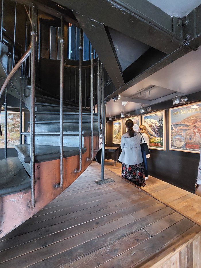 Photo de la "salle des affiches" se trouvant à la Tour de l'Horloge de Paris Gare de Lyon. On aperçoit l'escalier central au premier plan et les affiches d'époque en arrière plan.