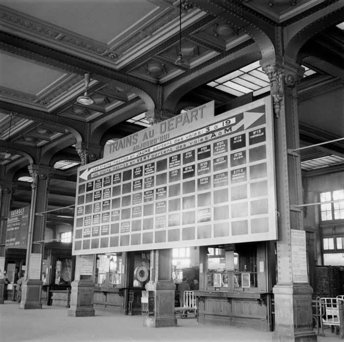 Dans les photos d'archives ligne R : une photo du panneau des départs à Paris Gare de Lyon dans la salle des fresques en 1958.