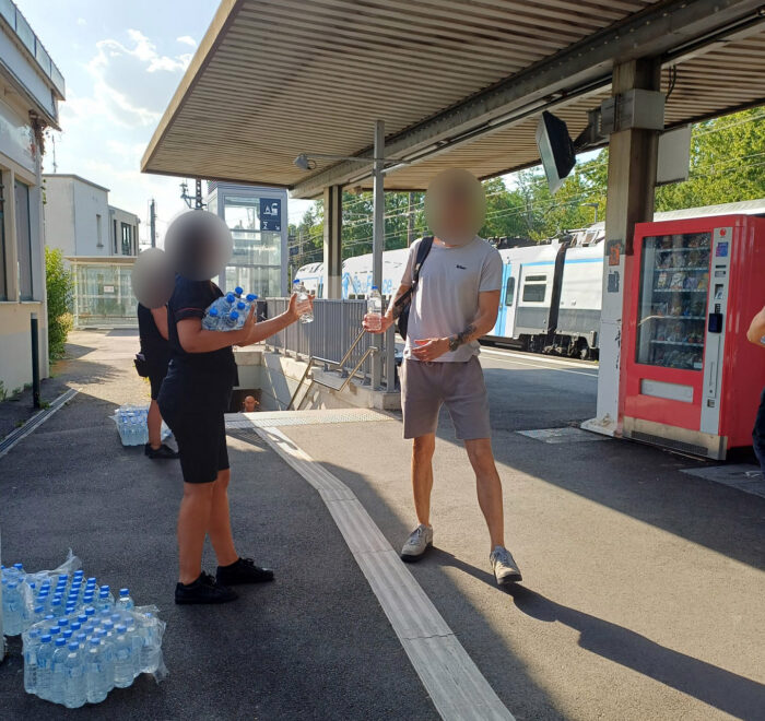 Suite à l'épisode de canicule : photo d'une distribution d'eau en gare de Moret - Veneux les Sablons par les agents de la Ligne R.